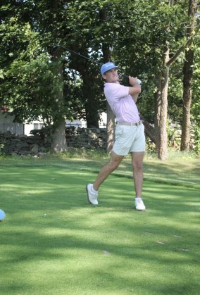 Golfer taking a swing on the green.