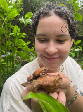 Bermingham holding a frog on a leaf in Hawaii.