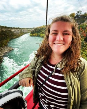 Female student riding a boat up a churning river
