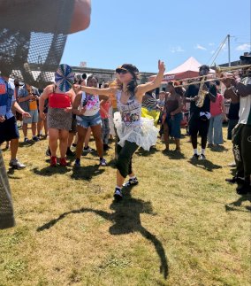 Jazz dancer energizes the crowd for musicians performing outdoors. 