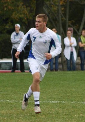 Male soccer player running downfield.