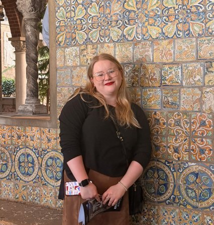 photo of Caulfield in front of unique tiled wall.