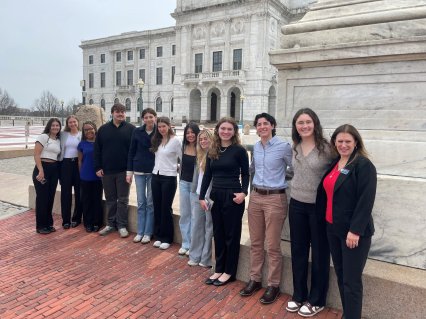 College students stand in front of RI statehouse