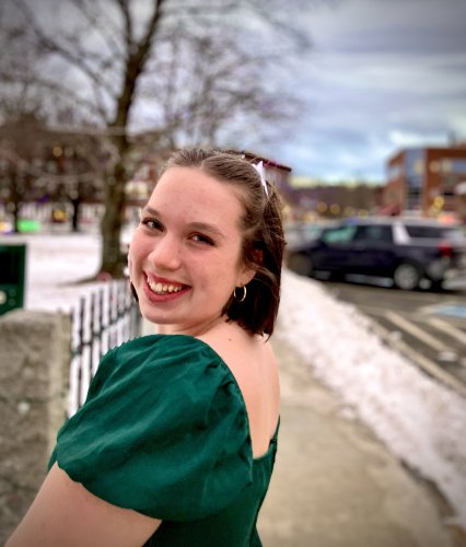 Cheevers smiling outside in a green dress.