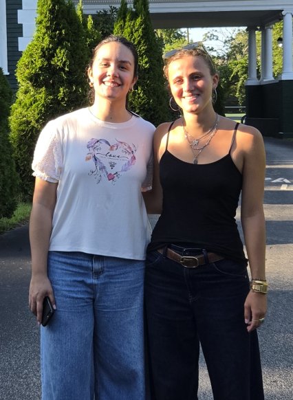 Two female teaching assistants posing casually outdoors