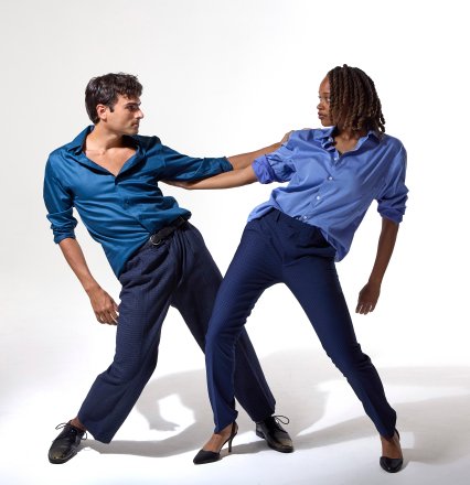 Male and female jazz dancer wearing blue and holding arms