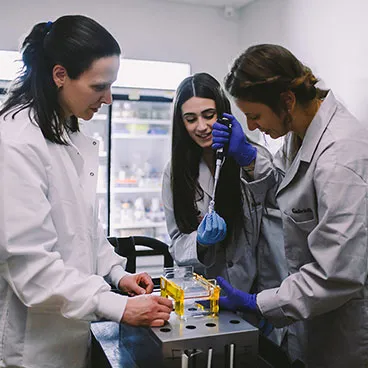 Dr. Anne Reid with undergraduate students in the lab